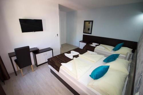 a hotel room with two beds and a flat screen tv at Hotel Villa Nadin in Mostar