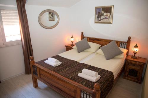 a bedroom with a wooden bed with two pillows at Hotel Villa Nadin in Mostar