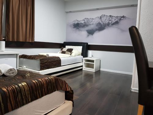 a bedroom with two beds and a painting on the wall at Hotel Villa Nadin in Mostar