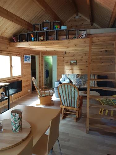 Cette cabane en rondins comprend un salon avec des murs en bois. dans l'établissement Insolite Chalet de pêche Sérénité - Bien Etre, à Ban-sur-Meurthe-Clefcy