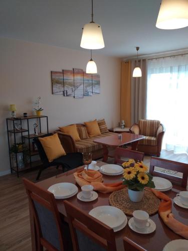 una sala de estar con una mesa y un sofá en M&K Apartament Słoneczna Wyspa - Sobieszewo, Wyspa Sobieszewska, en Gdansk