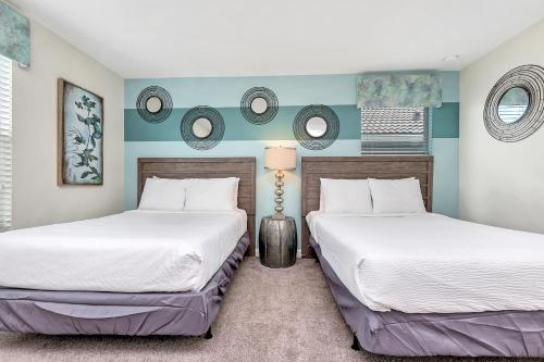 two beds in a bedroom with blue and white walls at Stylish Home wPrivate Pool&Spa, near Disney in Davenport