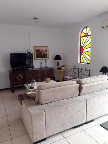 a living room with a couch and a stained glass window at Residencial Morada do Sol in Santa Maria