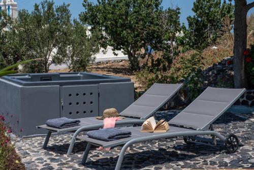 a picnic table with two chairs and a grill at Noelia Suites in Oia