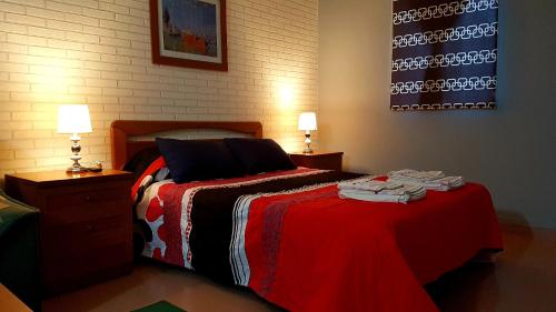 1 dormitorio con 1 cama con manta roja y 2 lámparas en Apartamento Loft II Select Real Caldas de Reis, en Caldas de Reis