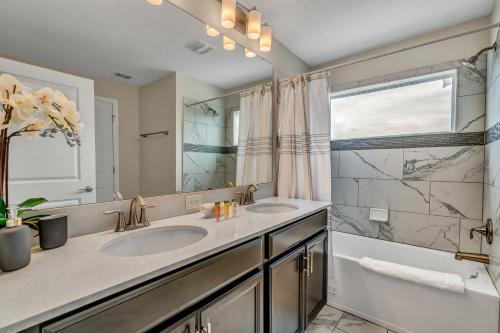 a bathroom with two sinks and a large mirror at Private Pool Themed Bedrooms FREE Waterpark in Kissimmee