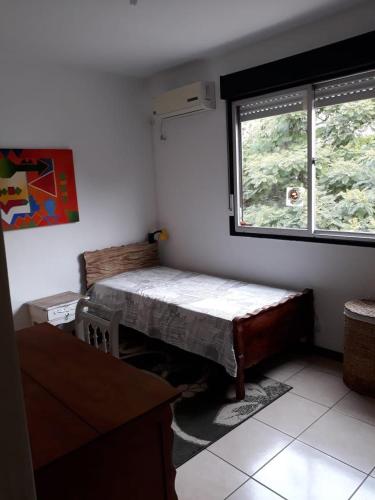 a small room with a bed and a window at Residencial Morada do Sol in Santa Maria