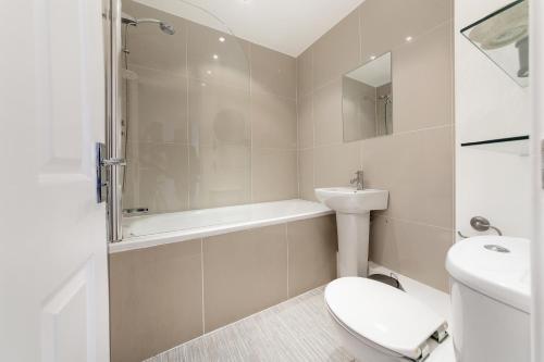 a white bathroom with a toilet and a sink at McLaren House Seahouses in Seahouses