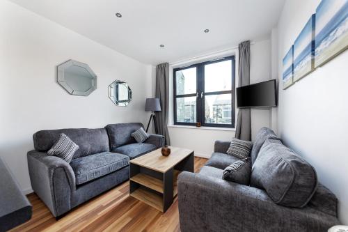 a living room with two couches and a table at McLaren House Seahouses in Seahouses