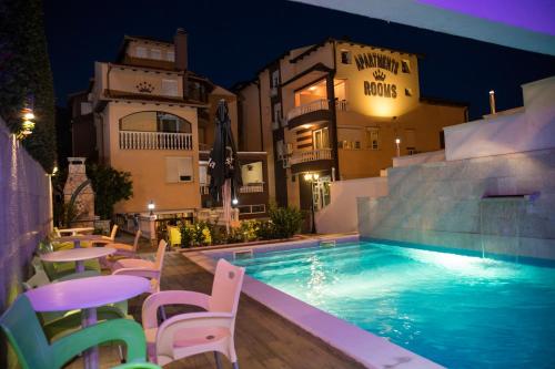 einen Pool mit Tischen und Stühlen neben einem Gebäude in der Unterkunft Hotel Villa Nadin in Mostar