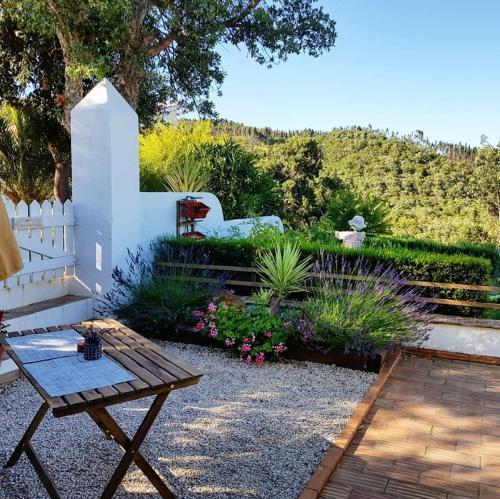 um jardim com um banco e uma cerca branca em Herdade Quinta Natura Turismo Rural em Aljezur