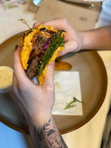 a person holding a sandwich in their hand at Penzion & Restaurace U Vily in Sezimovo Ústí