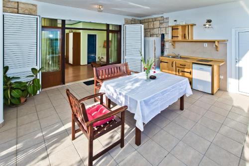 eine Küche mit einem Tisch, 2 Stühlen, einem Tisch und einer Küche in der Unterkunft Apartments Villa Marcelina in Hvar