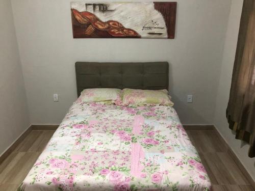 um quarto com uma cama com um cobertor rosa em Casa 8 condomínio Angra mambucaba em Angra dos Reis