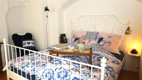 Un dormitorio con una cama blanca y azul con una mesa en Apartmán Horšovský Týn, en Horšovský Týn