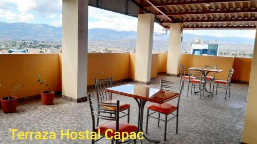 a restaurant with tables and chairs and mountains in the background at Hostal Capac in Ayacucho