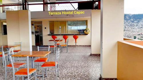 a restaurant with tables and red stools at Hostal Capac in Ayacucho