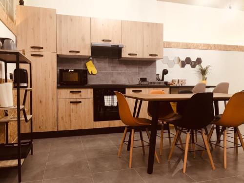 - une cuisine avec des placards en bois, une table et des chaises dans l'établissement LA88 Ground Apartment, à San Pawl il-Baħar