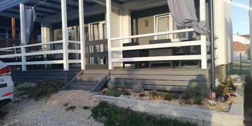 a house with a white railing on the porch at Holiday Home Sunny Deck in Pakoštane