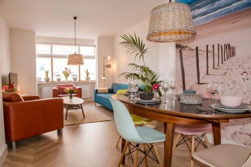a dining room and living room with a table and chairs at Beachhouse Anna, 1 minute walk to the beach and centre of Katwijk, Free private parking next to the house ! in Katwijk aan Zee