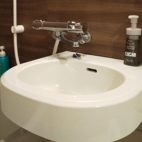 a white sink with a faucet on top of it at Hotel Route-Inn Kawaguchiko in Fujikawaguchiko
