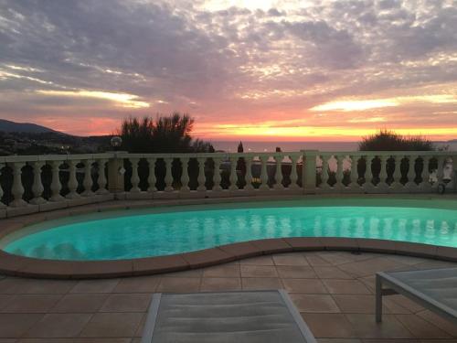 une piscine avec un coucher de soleil en arrière-plan dans l'établissement PROPRIANO, à Propriano
