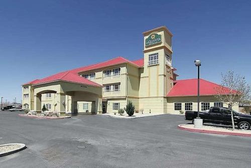 a building with a car parked in a parking lot at La Quinta by Wyndham Hobbs in Hobbs