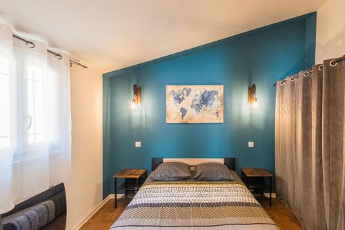a bedroom with a bed and a blue wall at L'urbain Narbonnais in Narbonne