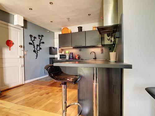 une cuisine avec un comptoir et un tabouret dans une pièce dans l'établissement Rue d'Isly, à Rennes