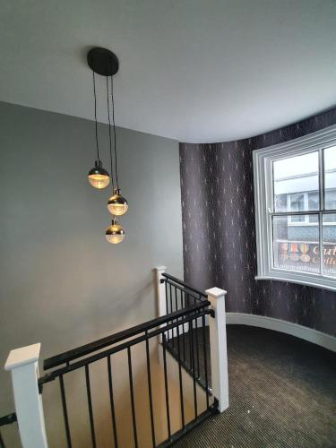 a hallway with a staircase with a window and lights at City Space in Doncaster