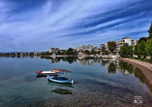 a boat in the water next to a city at Philoxenia Hotel in Lefkandi Chalkidas