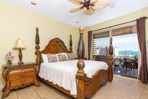 1 dormitorio con cama de madera y ventana en Bella Sirena Beautiful View - Condo 403-E en Puerto Peñasco