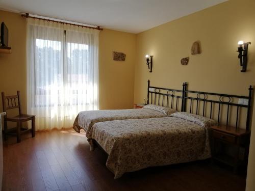 1 dormitorio con 2 camas y ventana en Casa Rural Lajafriz, en Fornillos de Aliste