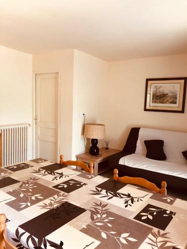 Cette chambre comprend deux lits, un lit et une lampe. dans l'établissement Les Gîtes du Moulin d Olt, à La Canourgue