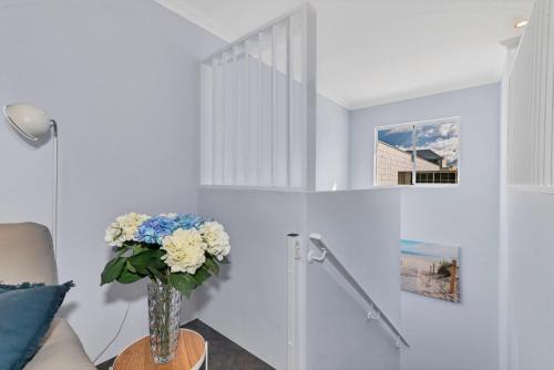 a vase of flowers on a table in a living room at Studio 11 Mandurah Marina in Mandurah