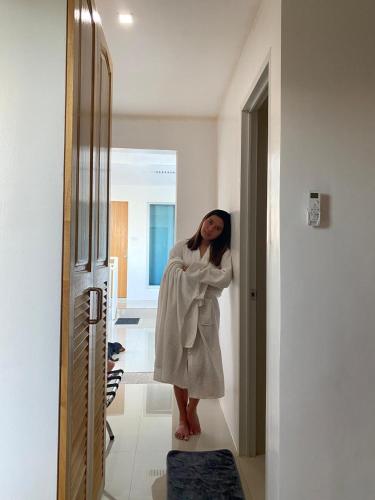 a woman in a white robe standing in a hallway at A Villas Resort & Restaurant in Zamboanguita
