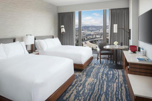 a hotel room with two beds and a table at Grand Hyatt at SFO in Millbrae