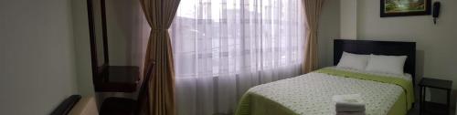a small bedroom with a bed and a window at Hotel Venecia Confort in Pasto