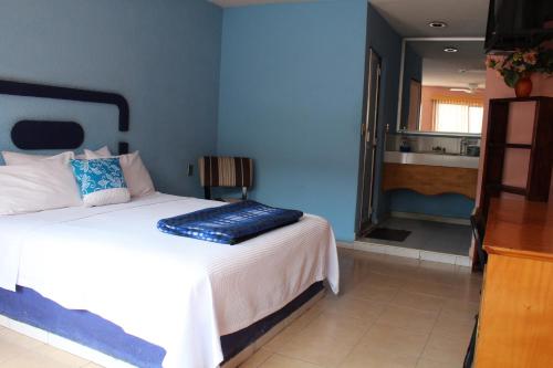 1 dormitorio con 1 cama con pared azul en Posada San José, Hotel, en Puebla