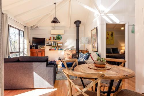 a living room with a table and a couch at Bandalong Cottages in Mudgee