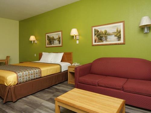um quarto de hotel com uma cama e um sofá em Quality One Motel em Weatherford