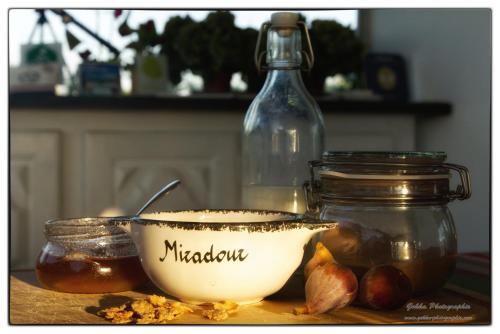 eine Schale Haselnüsse, ein Glas Honig und eine Flasche in der Unterkunft Maison d'hôtes City Break MIRADOUR in Bayonne