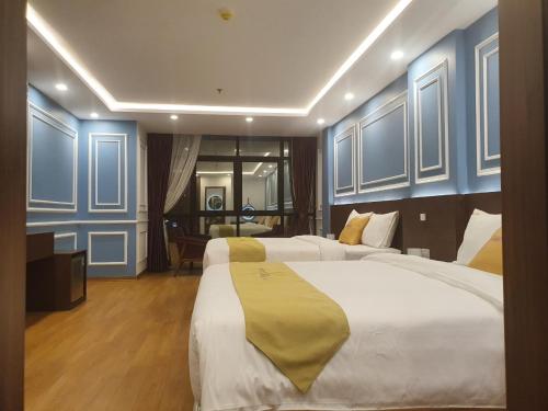 pokój hotelowy z 2 łóżkami i niebieskimi ścianami w obiekcie Hotel Villa Ju w mieście Hanoi