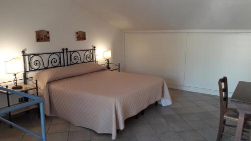 a bedroom with a large bed and a table at Casale Fonterosa in Montemerano