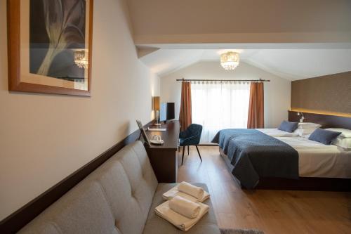 a hotel room with a bed and a couch at Átrium Rooms & Café in Sopron