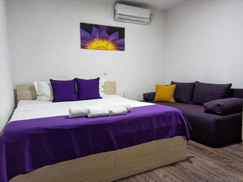 a bedroom with a large bed and a couch at Vila Magdalena in Gevgelija