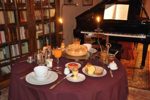 einen Tisch mit Teller mit Speisen und ein Klavier in der Unterkunft Domaine du Ris de Feu Chambres d'hôtes de charme in Chalais