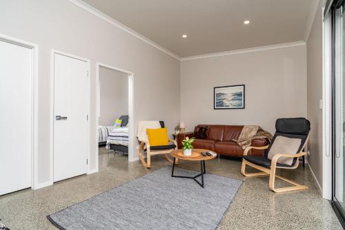 a living room with a couch and chairs at Northcoast Getaway in Mangawhai