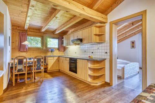 a kitchen with wooden cabinets and a table and chairs at Hotel Stefanie in Tirolo