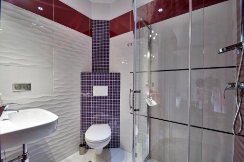 Un baño con ducha, inodoro y lavabo. en Aparthotel Globus - bezkontaktowa obsługa, en Łódź